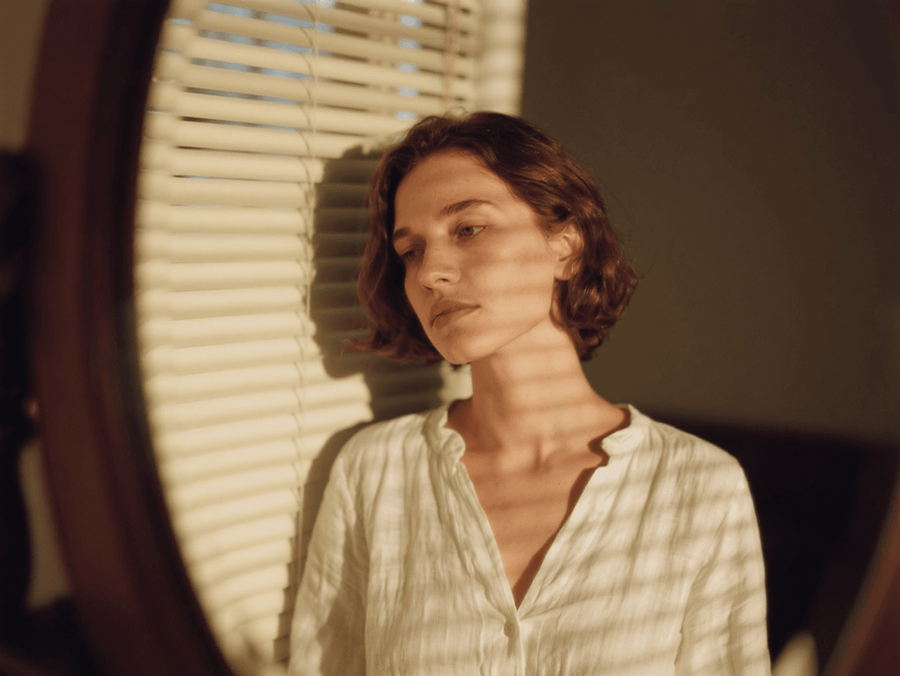 Woman next to blinds